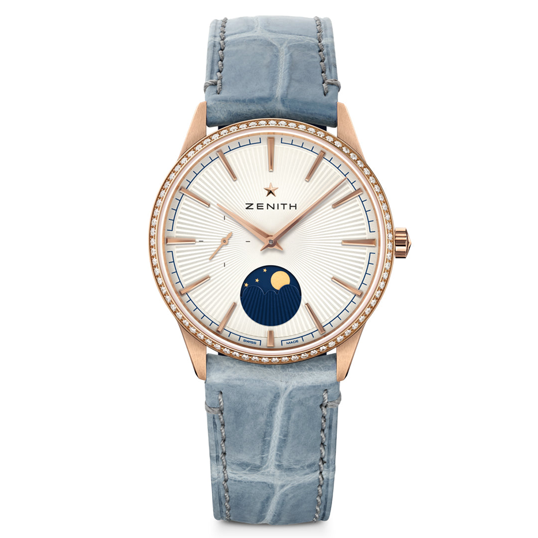 The ZENITH Elite Moonphase Elite 692 36mm Watch features an 18k rose gold case, blue alligator leather strap, a white dial with blue and gold hour markers, a moonphase at 6 o'clock, and a diamond-set bezel for elegance.