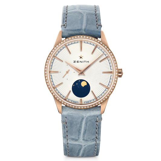 The ZENITH Elite Moonphase Elite 692 36mm Watch features an 18k rose gold case, blue alligator leather strap, a white dial with blue and gold hour markers, a moonphase at 6 o'clock, and a diamond-set bezel for elegance.