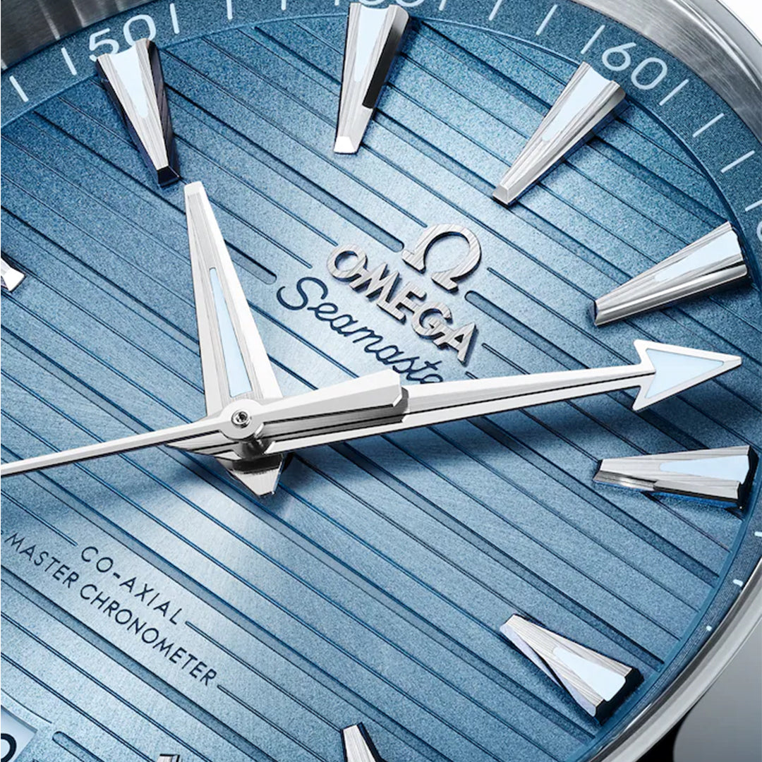 Close-up of the OMEGA Seamaster Aqua Terra 150M Co-Axial Master Chronometer 41mm watch face in blue, featuring silver hour markers and hands. The textured teak pattern dial displays "OMEGA," "Seamaster," and specs, with a brushed/polished finish and Super-LumiNova elements.