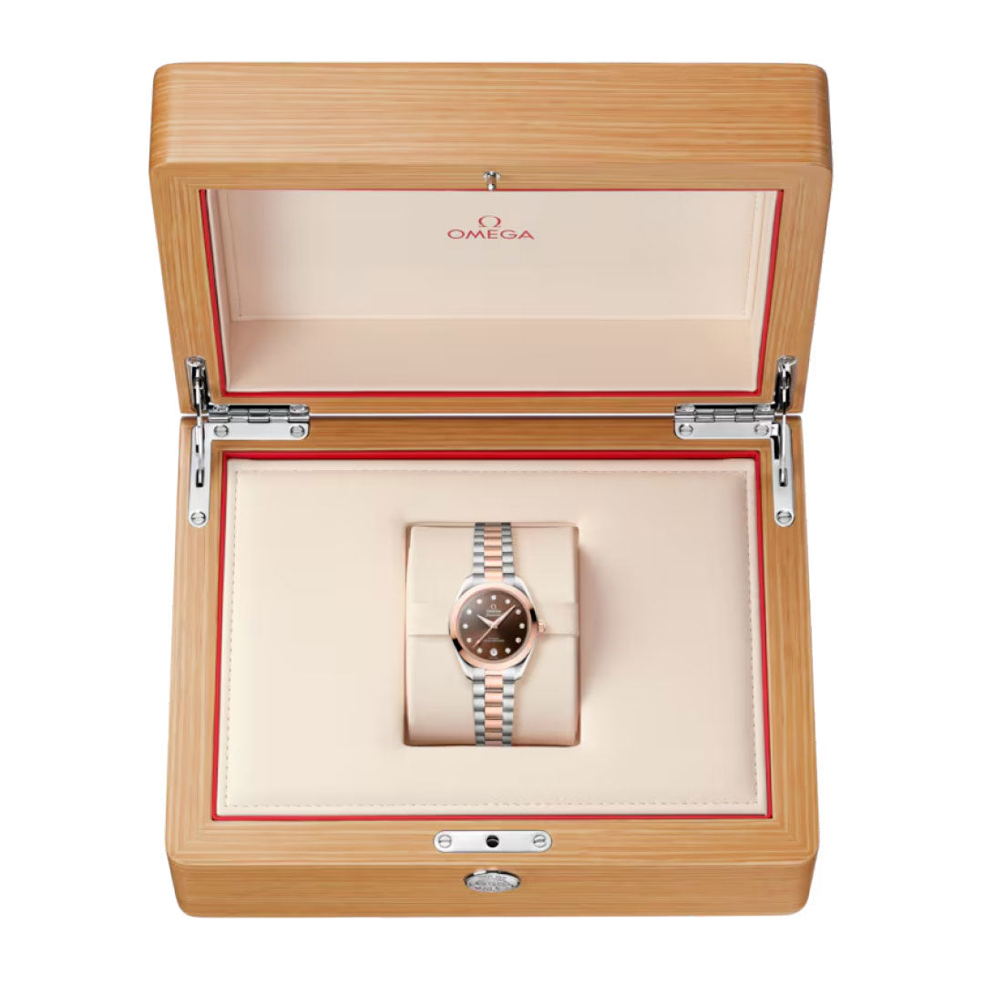 The OMEGA Seamaster Aqua Terra 150M Co-Axial Master Chronometer 30mm Watch is presented on a metal bracelet, displayed in an open light wood OMEGA box with a cream interior and red accents.