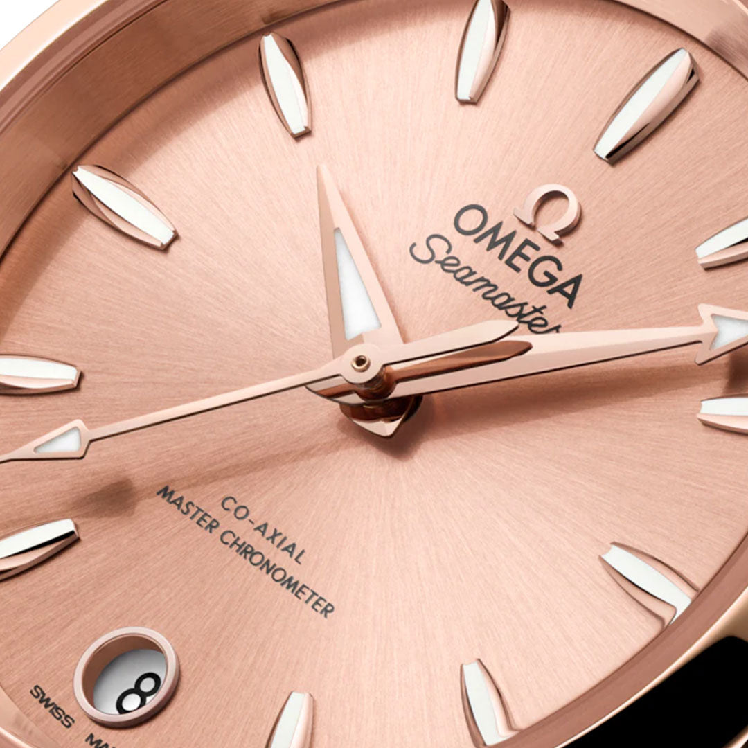 Close-up of the OMEGA Seamaster Aqua Terra Shades Co-Axial Master Chronometer 34mm watch, showcasing its rose gold dial in 18K Sedna™ Gold, triangular hour markers, date at 6 o’clock, and "Co-Axial Master Chronometer" on the dial.