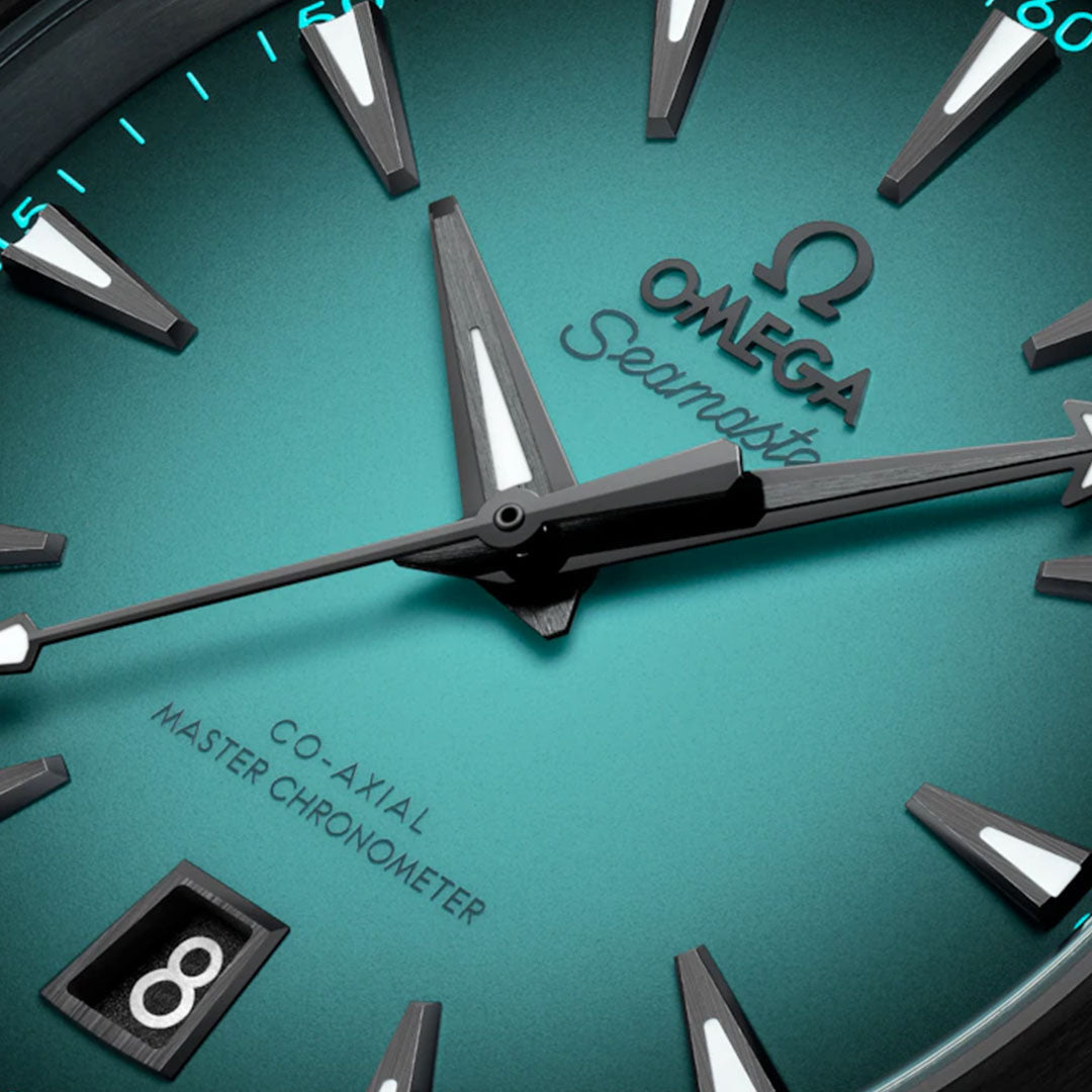 Close-up of the OMEGA Seamaster Aqua Terra 150M Co-Axial Master Chronometer 38mm Watch with teal face, silver hour markers, bold hands, date window at 6 o’clock, and signature "Seamaster" script with detailed OMEGA branding.
