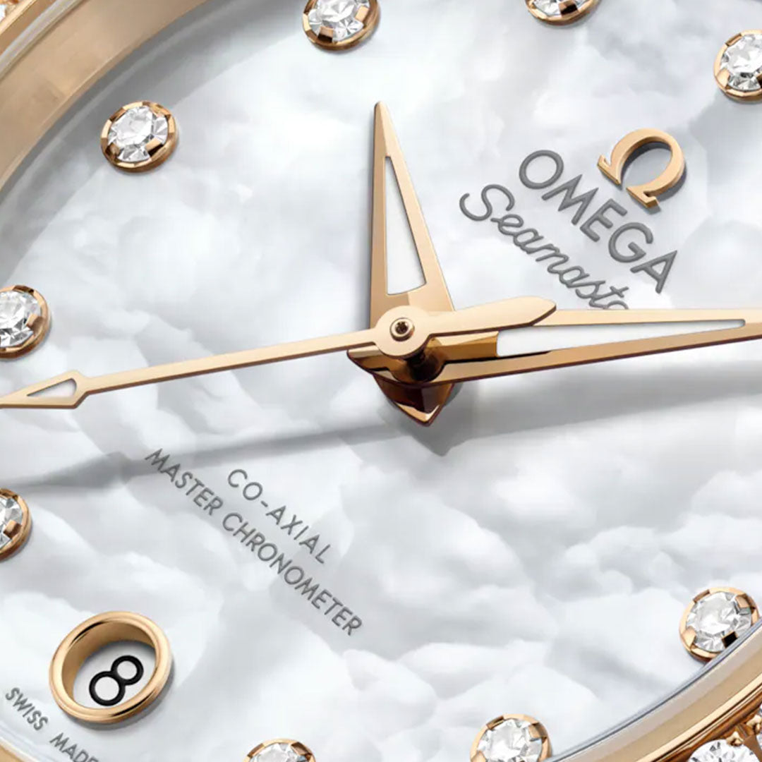 Close-up of the OMEGA Seamaster Aqua Terra 150M Co-Axial Master Chronometer 30mm watch, featuring Moonshine gold hands, diamond hour markers, white textured dial, date at 6 o’clock, and "Swiss Made" on the face.