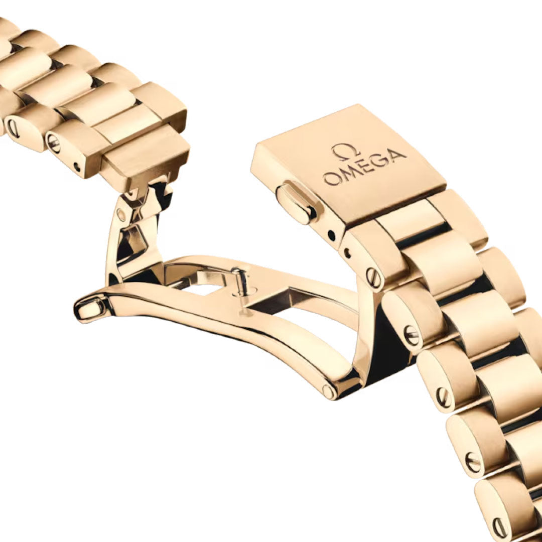 Close-up of an OMEGA Seamaster Aqua Terra 150M Co-Axial Master Chronometer 30mm watch bracelet in Moonshine gold, showing the open folding clasp with engraved OMEGA logo against a white background.