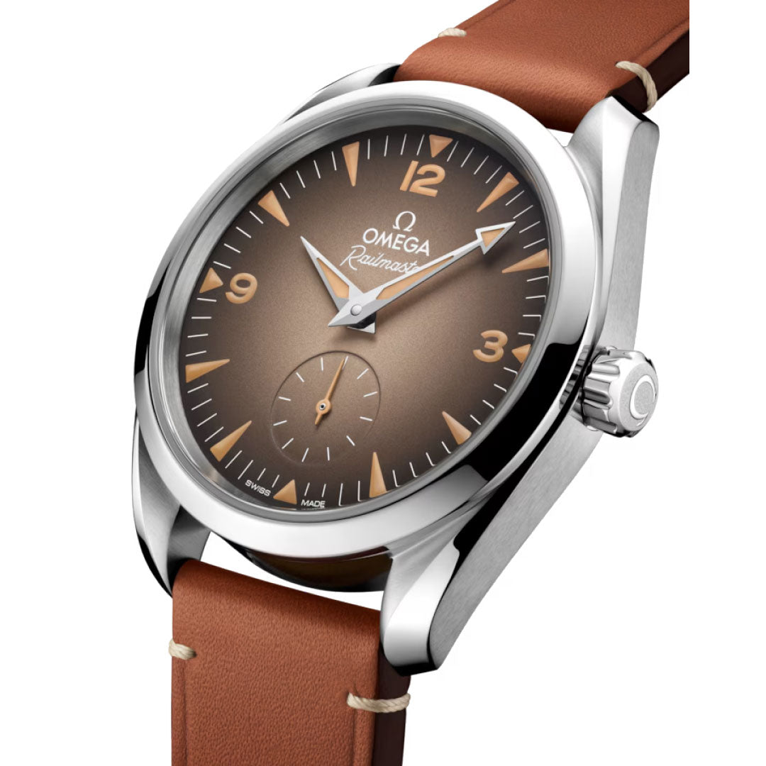 A close-up of the OMEGA Seamaster Railmaster Co-Axial Master Chronometer 38mm Watch, featuring a brown gradient dial, tan leather strap, stainless steel case, triangular and numeral hour markers, and a small seconds sub-dial at 6 o’clock.