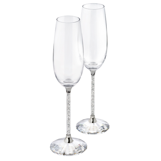 The Swarovski Crystalline Toasting Flutes, a set of two exquisite crystal flutes featuring elegant bases and long, slender stems, stand side by side against a plain background, poised to enhance any special occasion with their sophisticated charm.