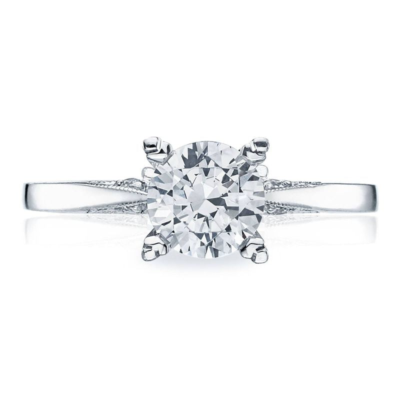 A close-up of the Tacori Classic Crescent solitaire engagement ring showcases a round brilliant diamond set on a sleek 18K white gold band. The Cathedral Foundation expertly secures the diamond with four prongs, enhancing its brilliance and timeless elegance.