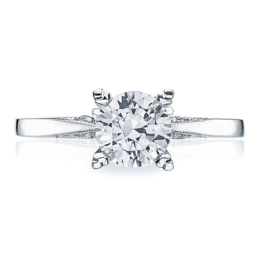 A close-up of the Tacori Classic Crescent solitaire engagement ring showcases a round brilliant diamond set on a sleek 18K white gold band. The Cathedral Foundation expertly secures the diamond with four prongs, enhancing its brilliance and timeless elegance.