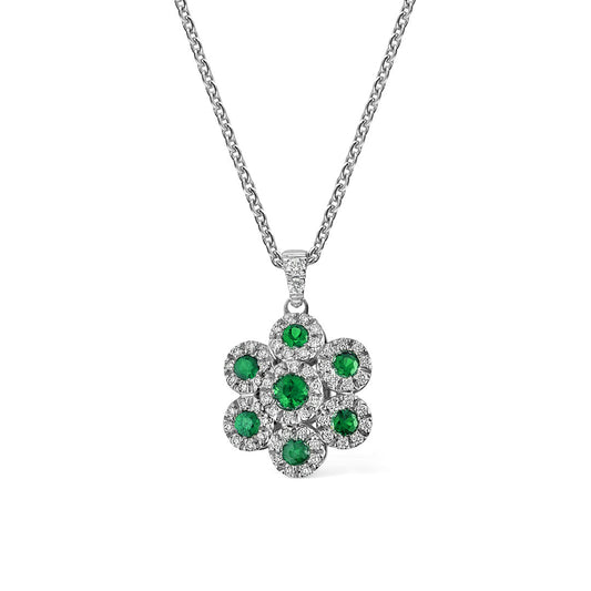 The Leo Pizzo Augusta Collection features an 18K white gold necklace with a flower-shaped pendant, showcasing seven round emeralds bordered by small clear stones for a sparkling cluster effect.