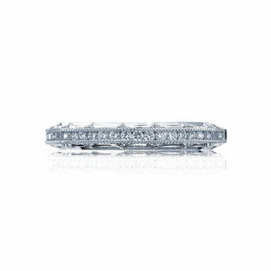 A side view of a sparkling Tacori Reverse Crescent 18K White Gold Round Brilliant Diamond Anniversary Ring glistens against a white reflective surface, reminiscent of the brilliance found in other stunning pieces designed by Tacori gemologists.