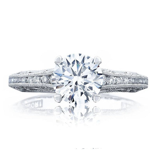 The Tacori Reverse Crescent 18K White Gold Round Brilliant Semi Mount Engagement Ring with Diamond Band showcases an elegant design. It features a large central round diamond and a detailed band adorned with smaller diamonds, reflecting the sophisticated design and expert craftsmanship enhanced by Tacori gemologists. The polished finish of the band further highlights its refined aesthetic.