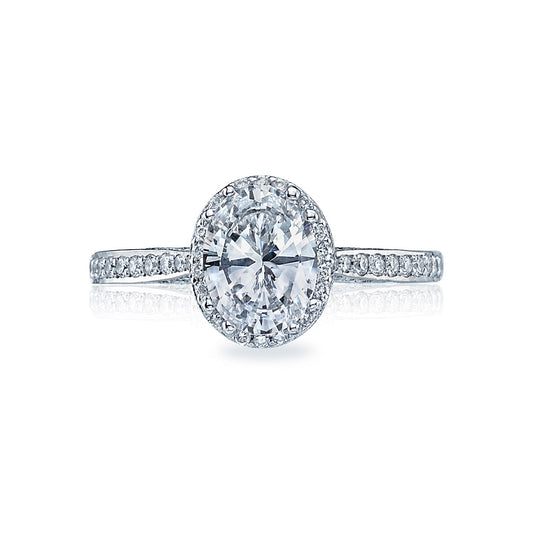 The Tacori Dantela 18K White Gold Oval Semi Mount Engagement Ring is a stunning work of art, featuring a central stone encircled by a hidden halo of sparkling diamonds. The cathedral foundation band is embellished with additional small diamonds, enhancing its brilliance and elegance—a true masterpiece by Tacori gemologists.