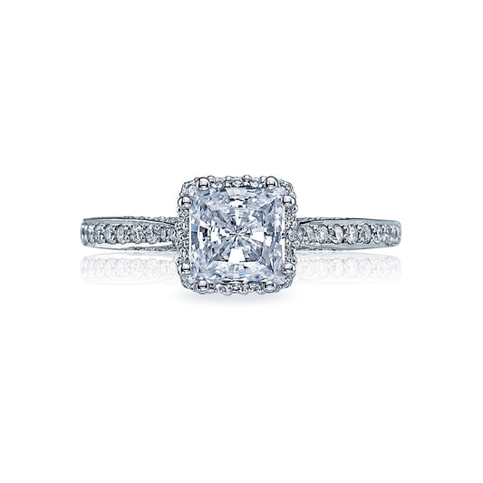 The Tacori Dantela Platinum Princess Cut Semi Mount with Diamond Band and Hidden Halo Engagement Ring showcases a stunning large square-cut diamond, evoking the elegance of a princess solitaire, surrounded by smaller diamonds. The band is adorned with gems that amplify its radiance. Expertly crafted by Tacori, it is elegantly presented against a plain white background.