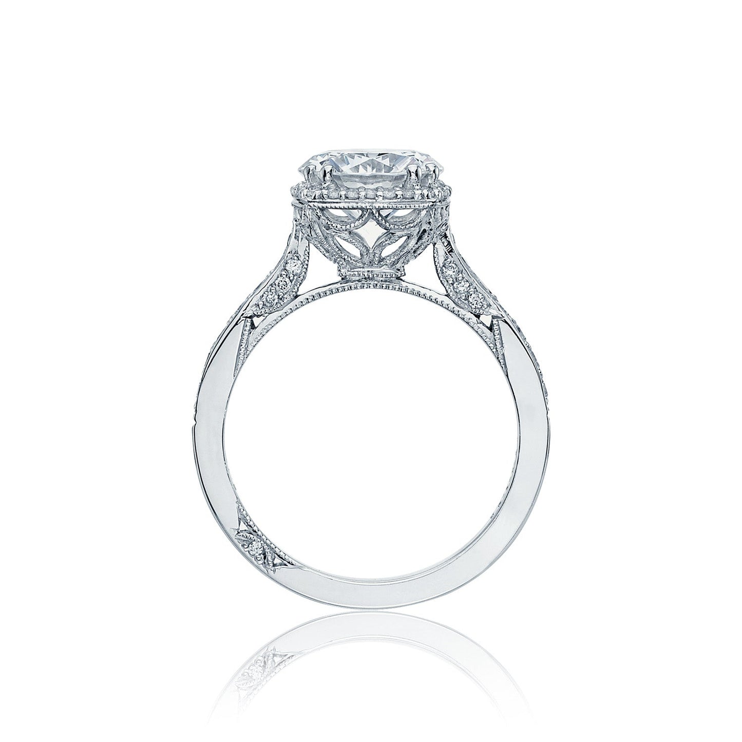 Introducing the Tacori Dantela 18K White Gold Round Brilliant Semi Mount with a Diamond Band and Hidden Halo Engagement Ring. This exquisite piece by Tacori features a Cathedral foundation adorned with an ornate band, showcasing a large, round diamond centerpiece. Intricate filigree work along the sides highlights its elegant and vintage design.