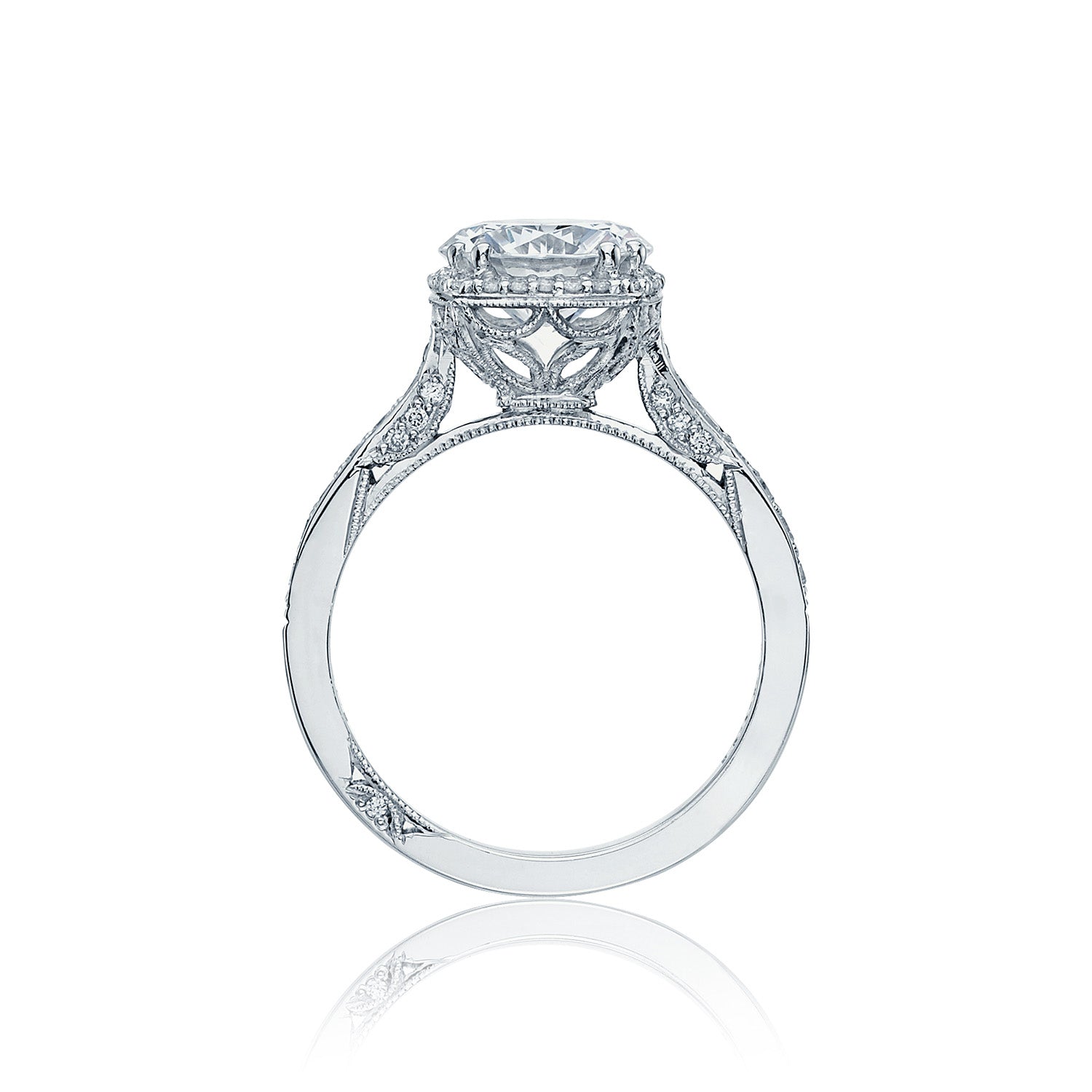 Introducing the Tacori Dantela 18K White Gold Round Brilliant Semi Mount with a Diamond Band and Hidden Halo Engagement Ring. This exquisite piece by Tacori features a Cathedral foundation adorned with an ornate band, showcasing a large, round diamond centerpiece. Intricate filigree work along the sides highlights its elegant and vintage design.