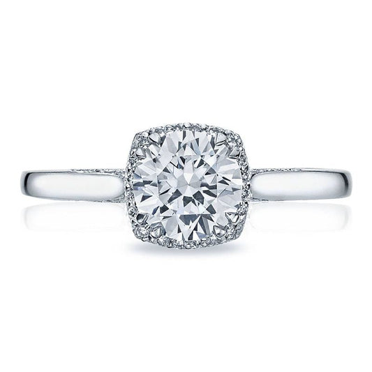 The Tacori Dantela engagement ring showcases a round brilliant diamond centered in 18K white gold, highlighted by a subtle hidden halo of smaller diamonds. The band offers a sleek and polished finish for an elegant touch.