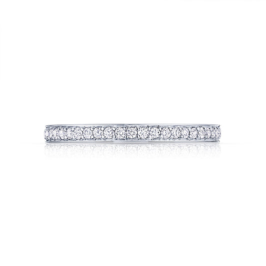 The Tacori Dantela 18K White Gold Round Brilliant Diamond Anniversary Ring embodies Tacori's timeless elegance with its continuous line of small, sparkling diamonds set against a plain white background.