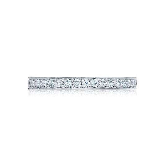 Displayed against a white background is the Tacori Dantela Platinum Round Brilliant Diamond Anniversary Ring, a slim and elegant silver band adorned with small, sparkling diamonds that showcase its classic design.