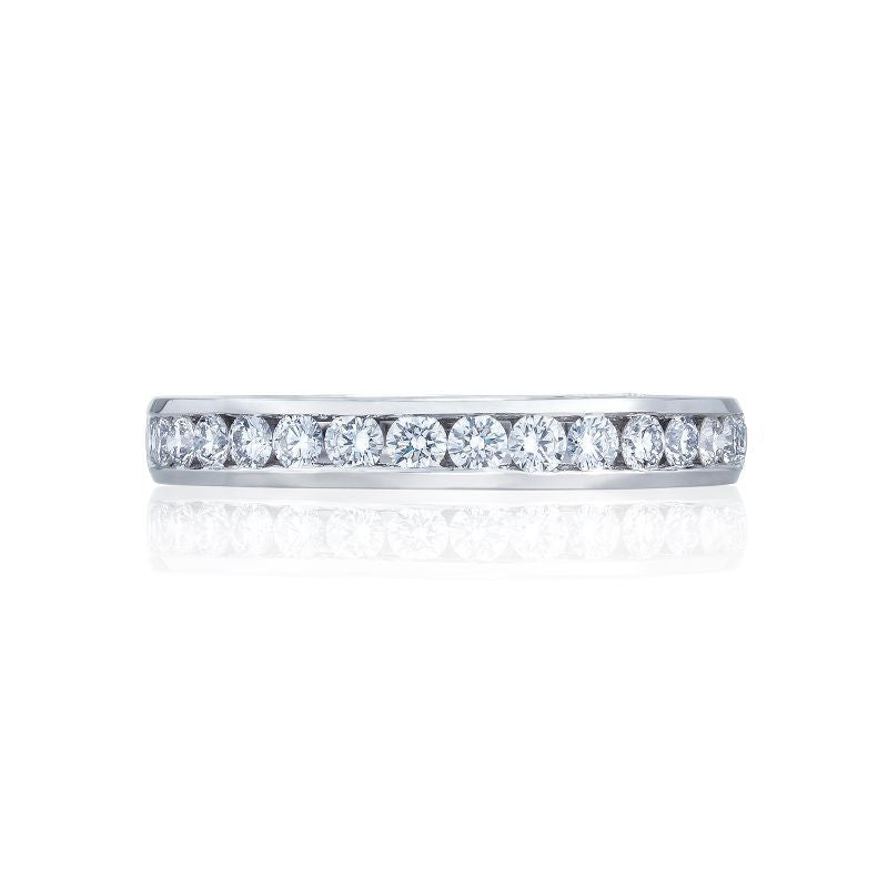 Introducing the Tacori Dantela 18K White Gold Channel Set Round Brilliant Anniversary Ring by Tacori. This stunning ring is crafted from high-quality 18K white gold and showcases a row of small, dazzling diamonds set along the band. Perfect as an elegant, diamond-studded engagement ring choice, it makes for a timeless addition viewed beautifully against a white background.