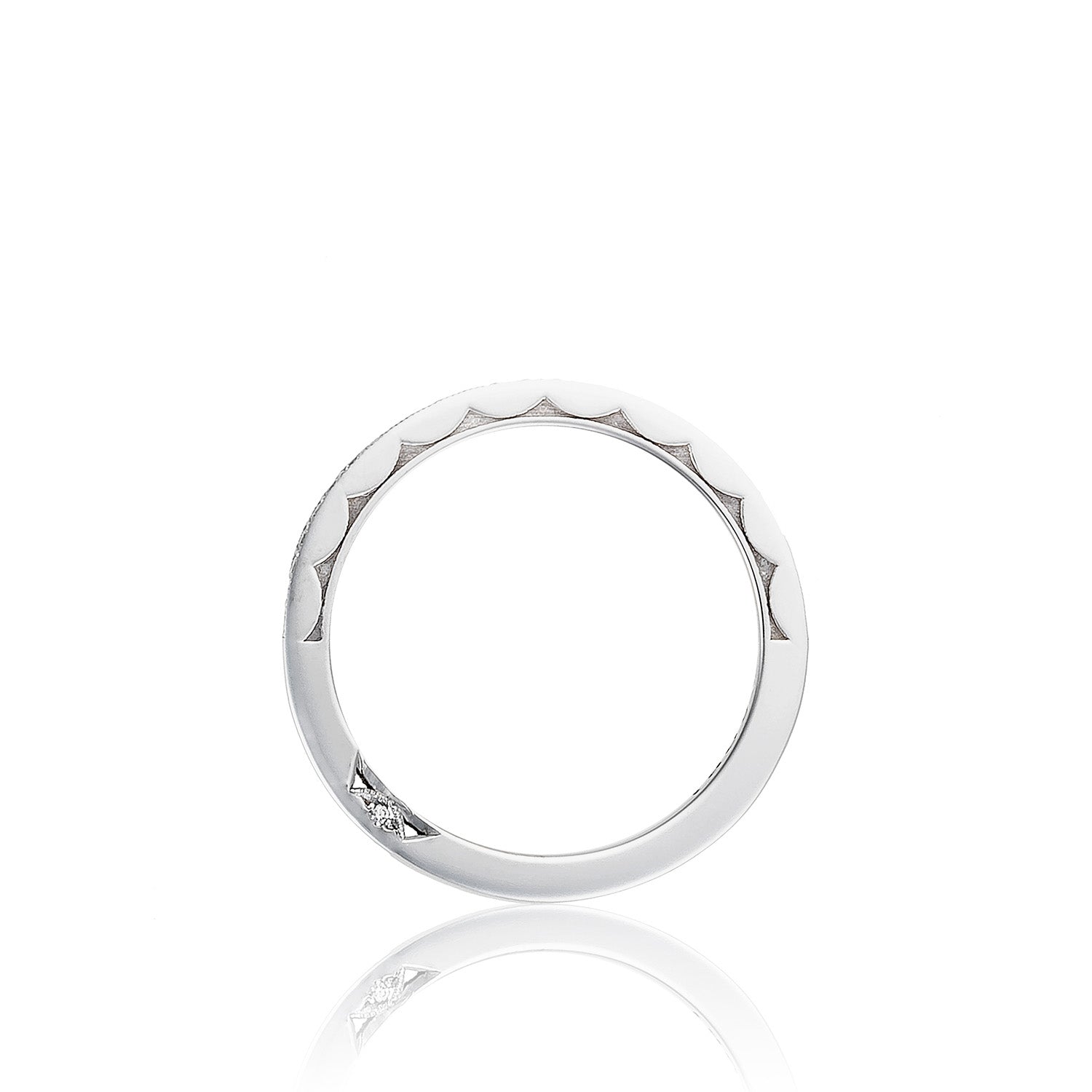 The Tacori Sculpted Crescent 18K White Gold Pavé Round Brilliant Diamond Anniversary Ring showcases a sleek, thin silver band with a distinctive scalloped edge design on the upper half and a small diamond accent on the bottom. Its classic engagement ring style is beautifully highlighted against a white background with subtle reflections.