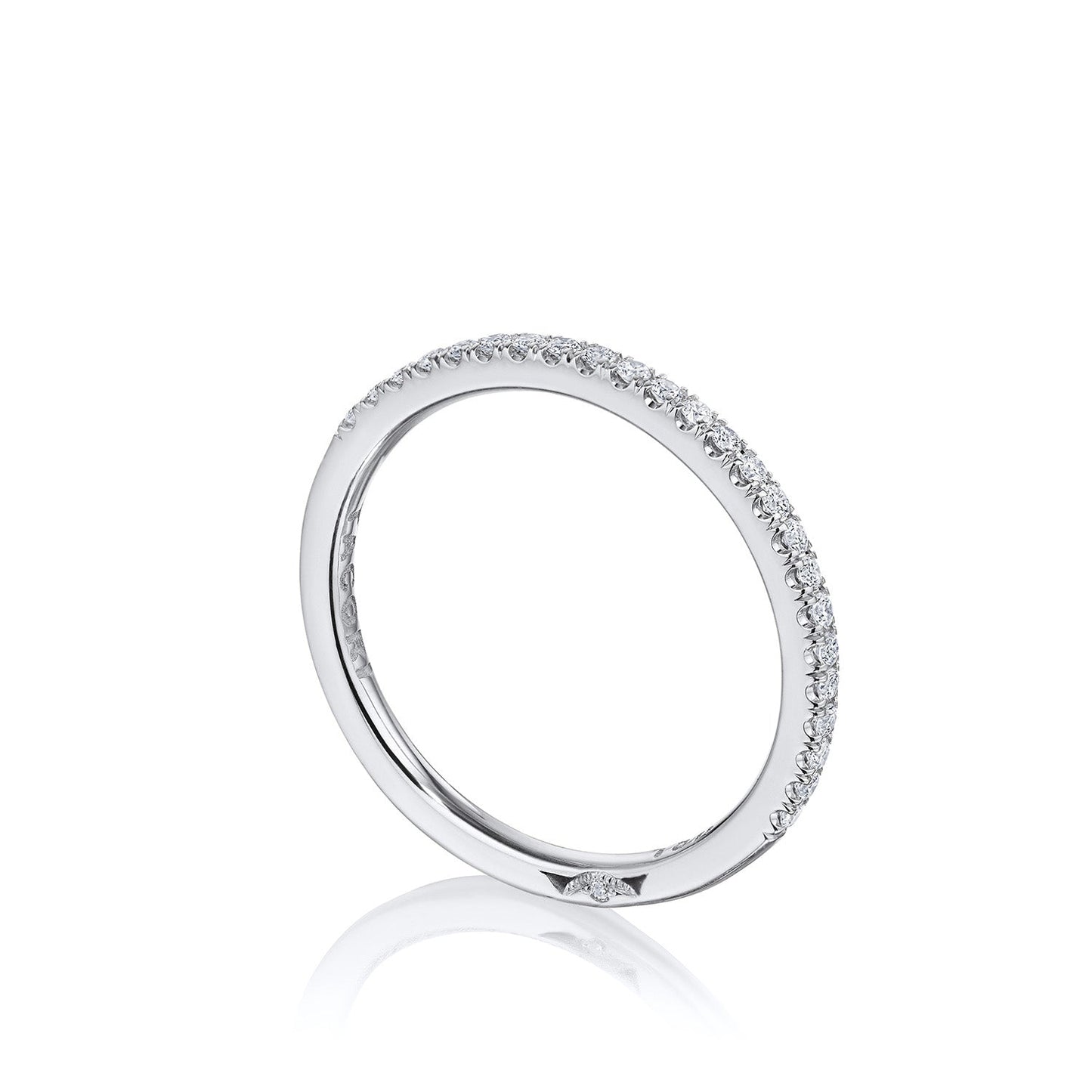 A slim, elegant Tacori ring crafted in 18K white gold features small, sparkling French pavé-set diamonds evenly spaced along its surface. Displayed against a white background, its simplicity and brilliance evoke the exquisite nature of TACORI designs.