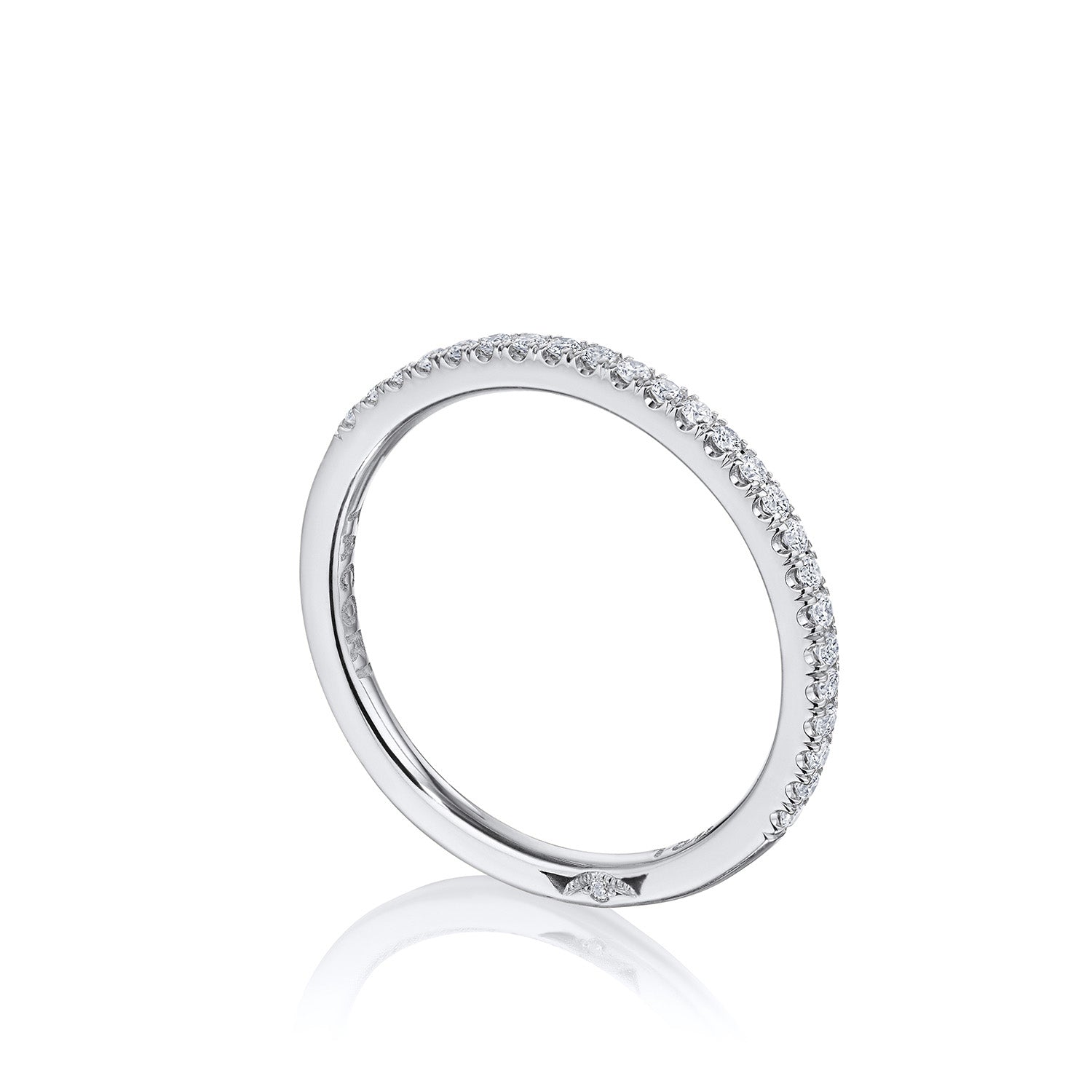 A slim, elegant Tacori ring crafted in 18K white gold features small, sparkling French pavé-set diamonds evenly spaced along its surface. Displayed against a white background, its simplicity and brilliance evoke the exquisite nature of TACORI designs.