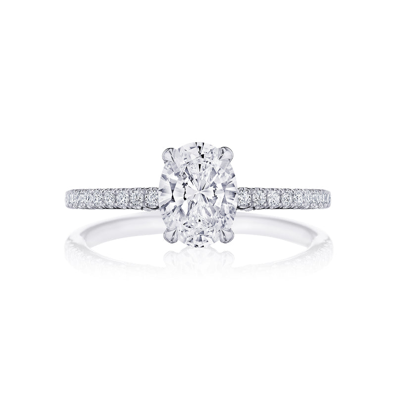 The Tacori Simply Platinum Oval Semi Mount with Diamond Band and Hidden Halo Engagement Ring exudes elegance with its central oval-cut diamond, complemented by a slender band embellished with delicate, sparkling diamonds. This stunning piece is beautifully displayed on a plain white background.