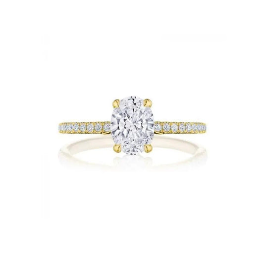 The Tacori Simply 18K Yellow Gold Oval Semi Mount Engagement Ring showcases a stunning oval diamond at its center, complemented by a French pavé band adorned with small round diamonds for a dazzling sparkle. Styled after Tacori's intricate crescent designs, this exquisite piece is elegantly displayed against a plain white background.