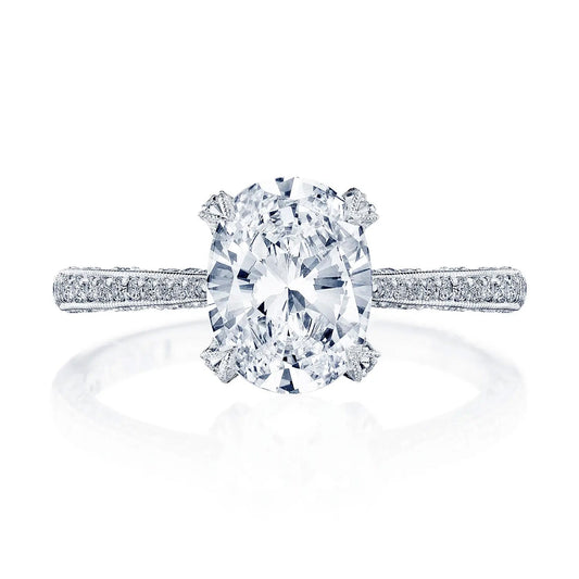 The Tacori Classic Crescent 18K White Gold Oval Semi Mount with Diamond Band and Hidden Halo Engagement Ring is a breathtaking piece featuring a prominent oval center stone in a prong setting. The band is embellished with small round diamonds, creating a shimmering effect that encapsulates the timeless elegance of solitaire style. Displayed against a white background, it beautifully captures the essence of romance.