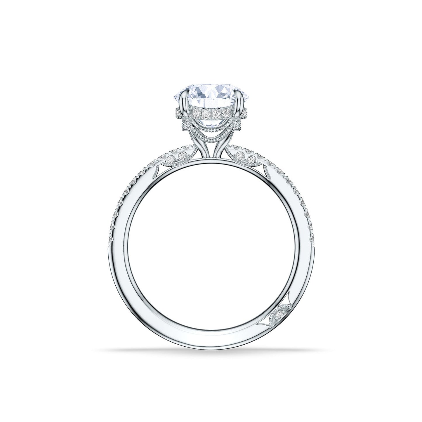 The Tacori Simply 18K White Gold Round Brilliant Semi Mount Engagement Ring features a large round diamond atop its band, adorned with intricate bridal details and pavé diamonds for an elegant and luxurious look. Displayed upright against a white background, this stunning piece also includes a hidden halo for added brilliance.