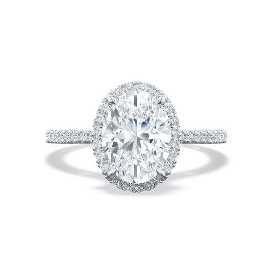 A close-up image of the Tacori Simply Tacori 18K White Gold Oval Semi Mount with Diamond Band and Halo Engagement Ring, featuring a sophisticated design with a bloom solitaire and a halo of smaller diamonds, all set on a delicate, diamond-encrusted band. The piece is elegantly displayed against a white background.