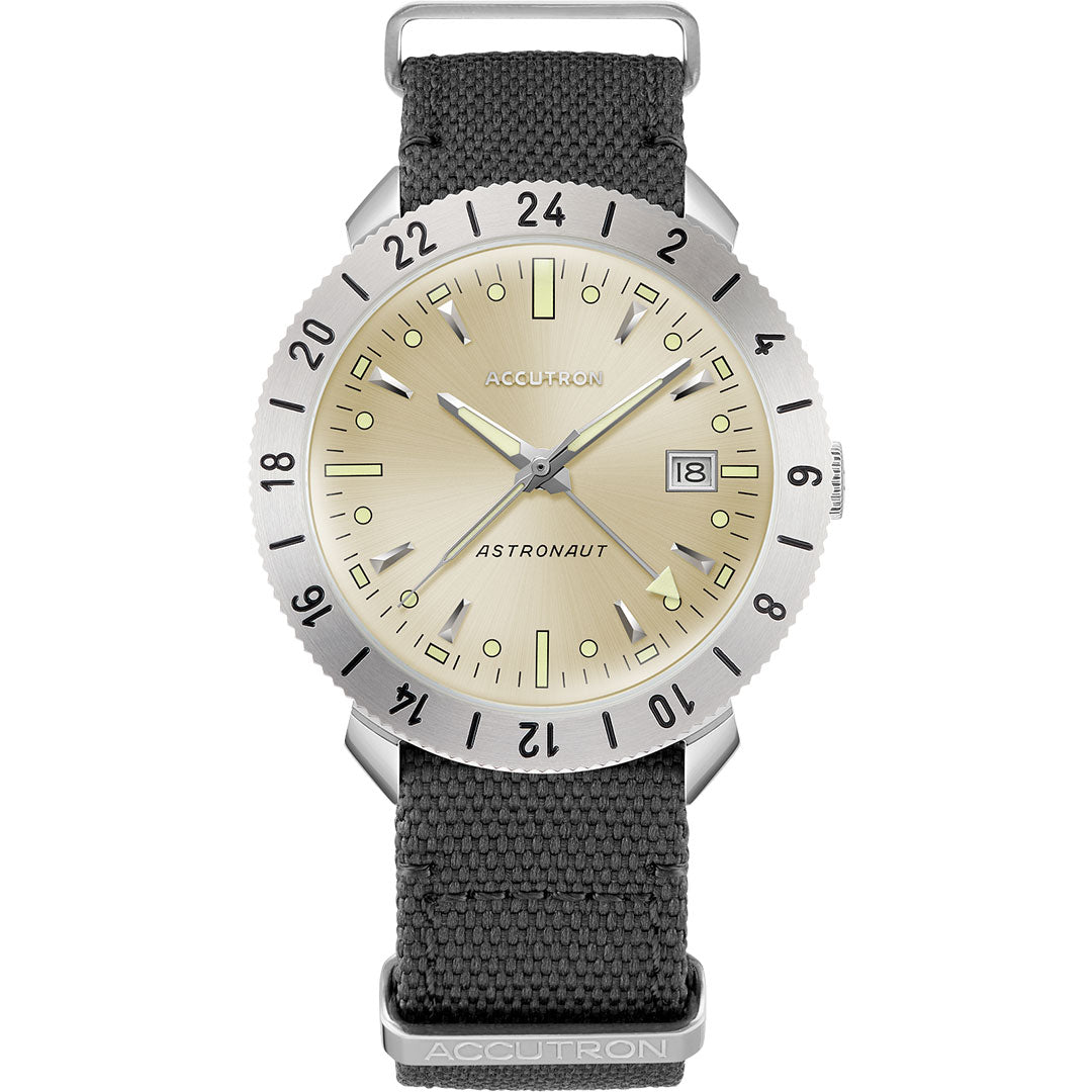The Accutron Astronaut LTi Automatic 41mm Watch by Accutron features a silver case, beige dial with black markers, date at 3 o’clock, black fabric strap, 24-hour bezel, and classic design inspired by the original titanium GMT watch.