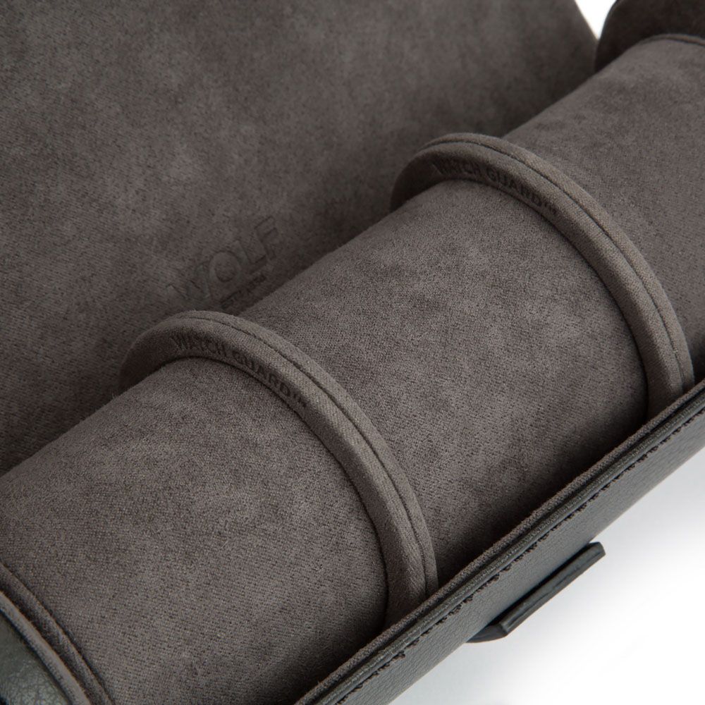 Close-up of a WOLF 1834 Blake Watch Roll With Capsule in Black/Grey, showing the “WOLF” branding embossed on the inner lining, two padded loops, and a soft, textured interior designed to protect your watches.