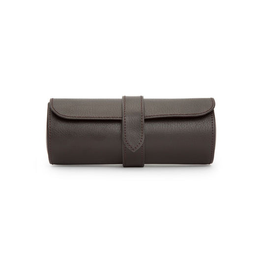 Dark brown, cylindrical leather watch roll with a flap and a central strap closure, displayed on a white background. The WOLF 1834 Blake Triple Watch Roll Brown by WOLF is beautifully handcrafted—perfect for storing your timepieces in style.