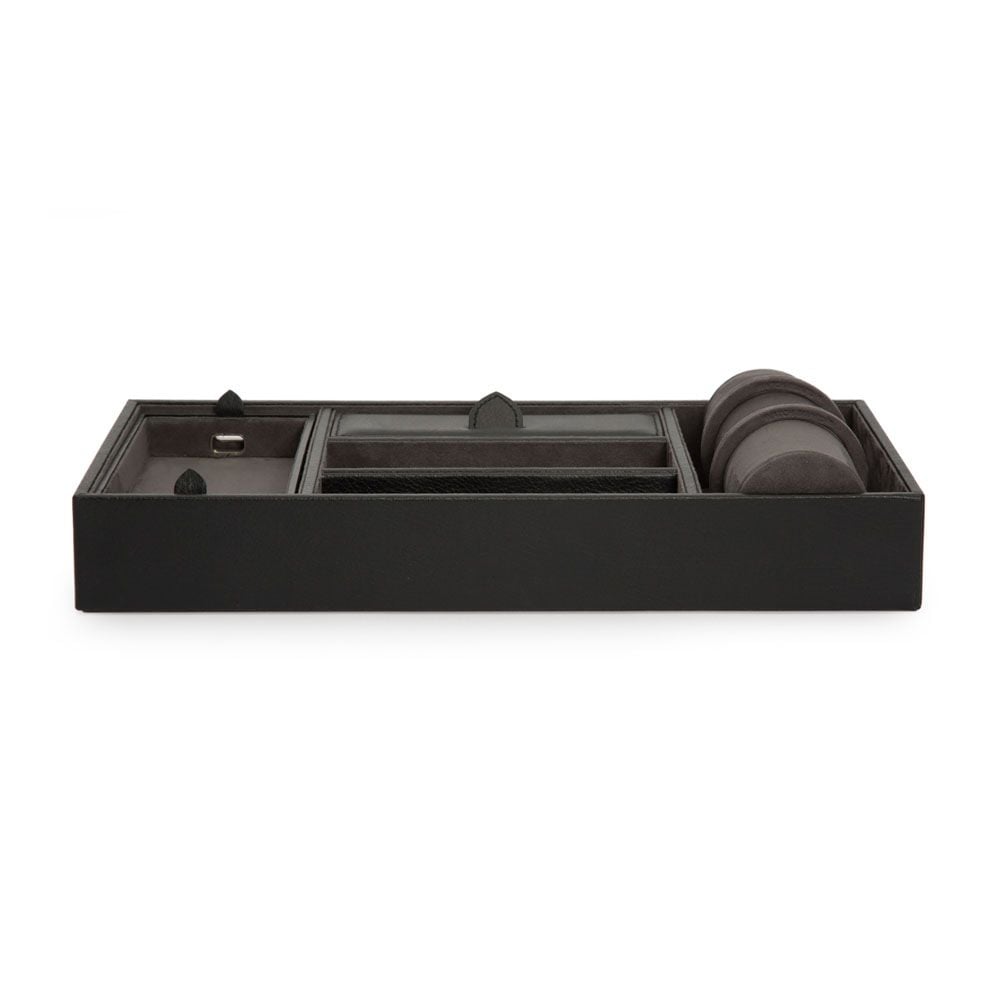 The WOLF 1834 Blake Valet Jewellery and Watch Tray With Cuff by WOLF is a rectangular black leather organizer with compartments for keys, small accessories, and a dedicated watch cuff, shown from the front.