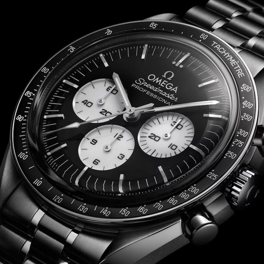 A close-up of the OMEGA Speedmaster Moonwatch Professional Co-Axial Master Chronometer Chronograph 42mm, featuring a black dial, three white subdials, tachymeter bezel, and stainless steel bracelet, displayed on a black background.