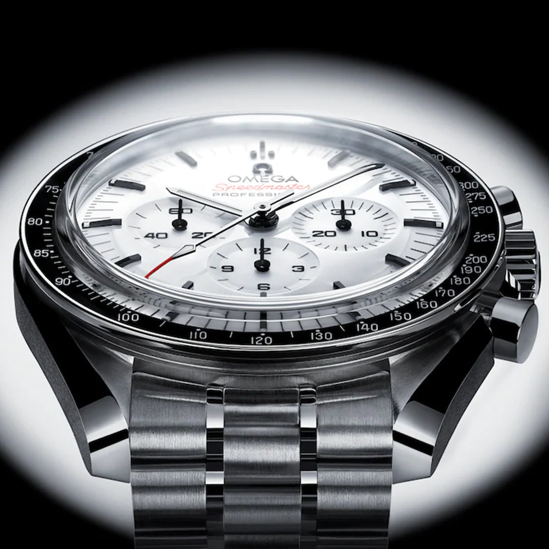 Close-up of the OMEGA Speedmaster Moonwatch Professional Co-Axial Master Chronometer Chronograph 42mm, featuring a white dial, black bezel, and metal bracelet, displayed against a black gradient background.