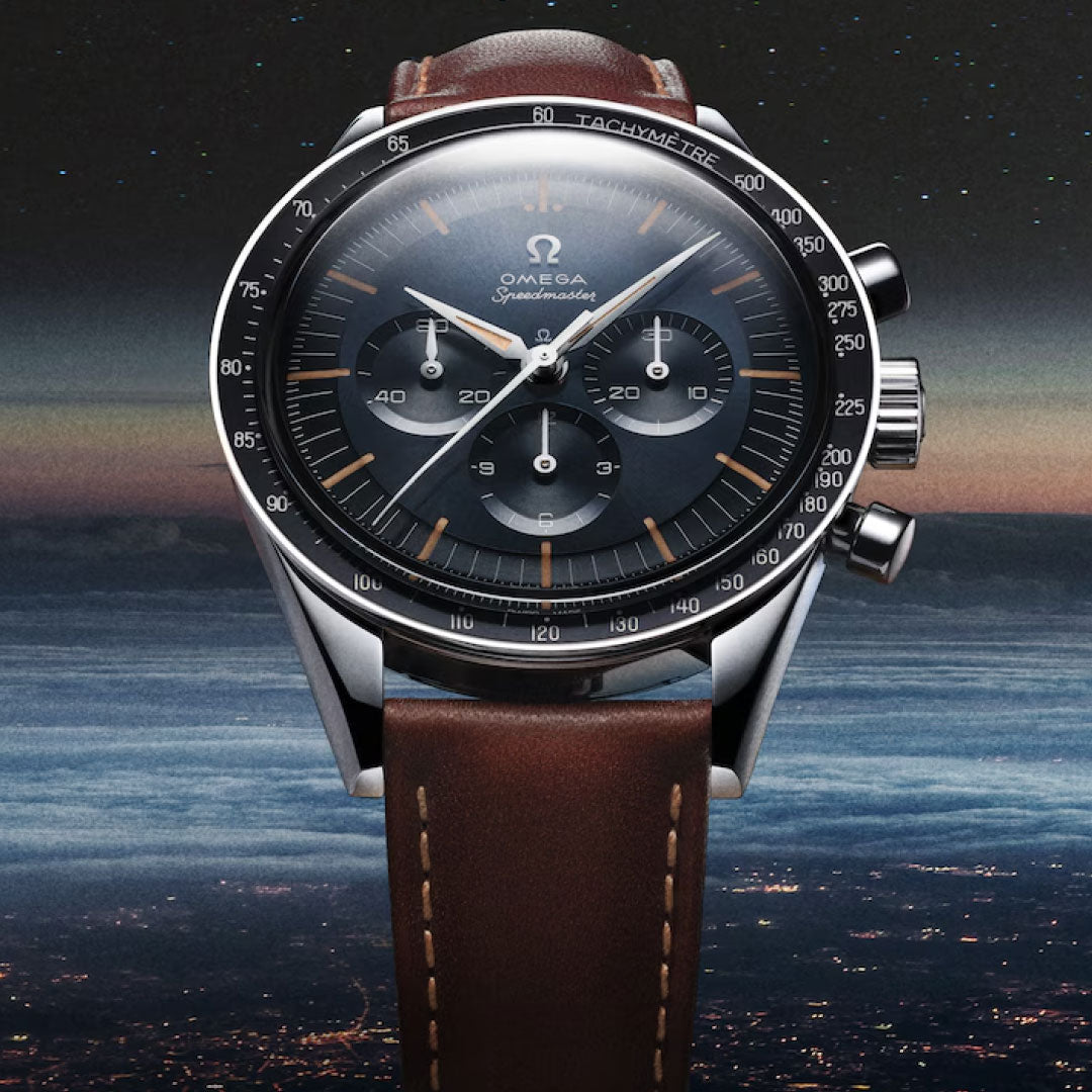 A close-up of the OMEGA Speedmaster First OMEGA in Space Co-Axial Master Chronometer 39.7mm Watch with a brown leather strap, set against Earth’s horizon and a starry night sky.