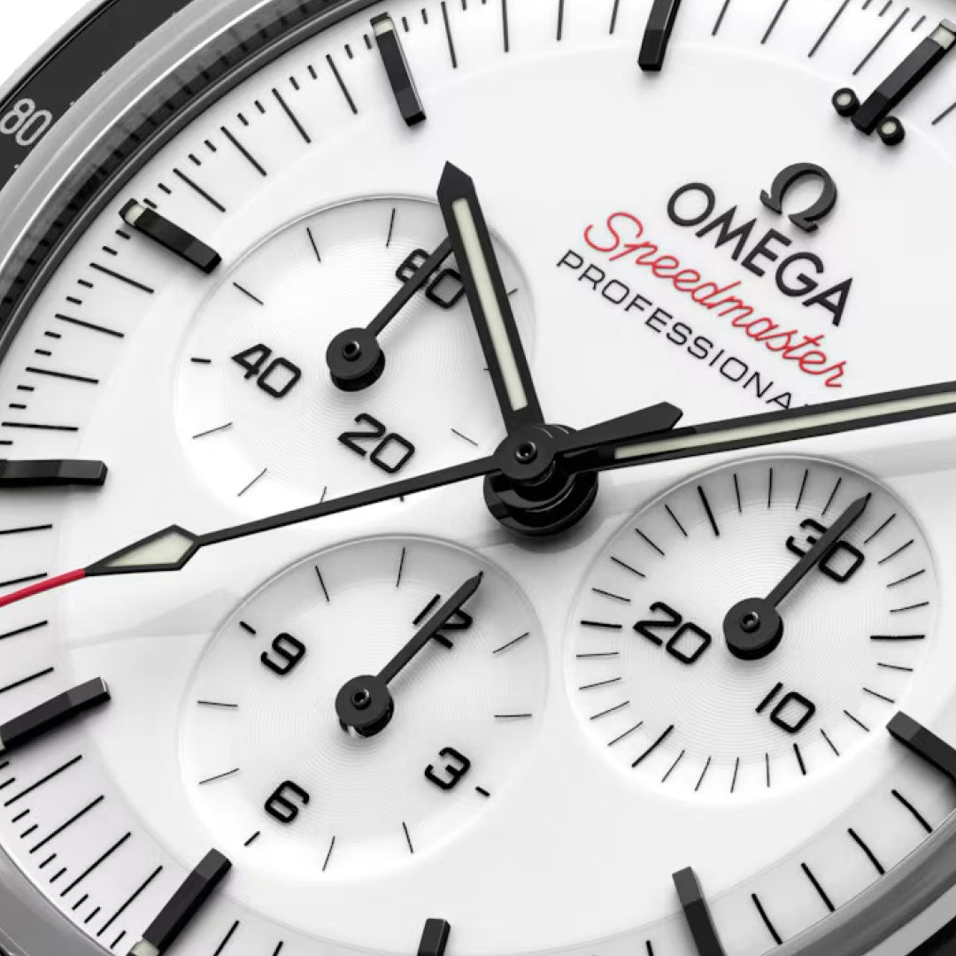Close-up of the OMEGA Speedmaster Moonwatch Professional Co-Axial Master Chronometer 42mm, featuring black hands, three chronograph subdials, black hour markers, and red Speedmaster text on white—an iconic OMEGA timepiece.