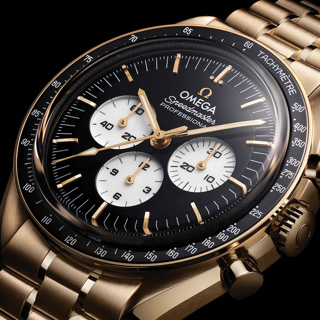 Close-up of an OMEGA Speedmaster Moonwatch Professional Co-Axial Master Chronometer 42mm with a gold case, black dial, three white subdials, gold hour markers, tachymeter bezel, and 18K Moonshine Gold bracelet.