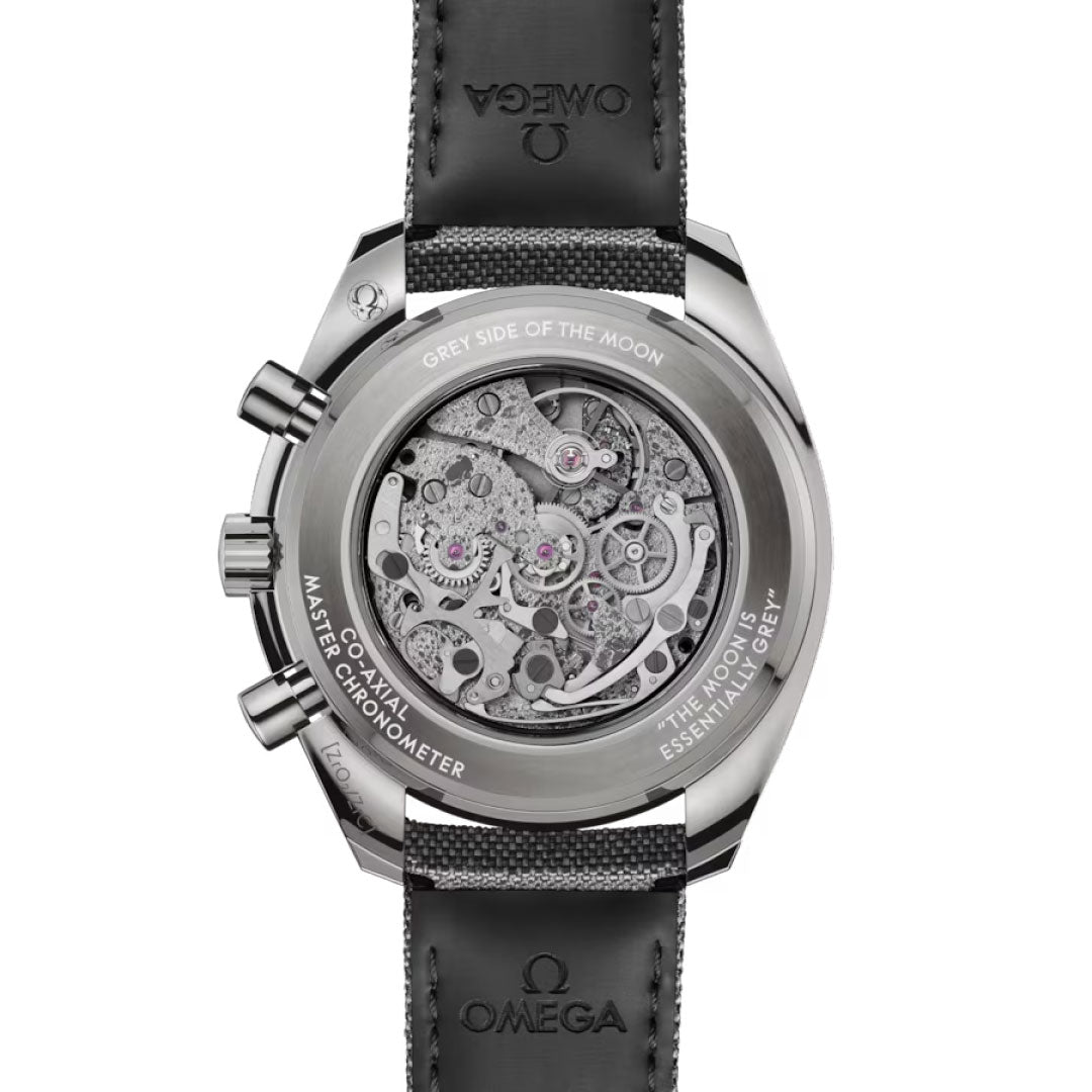 A close-up of the OMEGA Speedmaster Dark Side of the Moon Co-Axial Master Chronometer 44.25mm shows its intricate exposed movement, metallic case, and black leather strap, with model details and the iconic OMEGA logo engraved on the back.