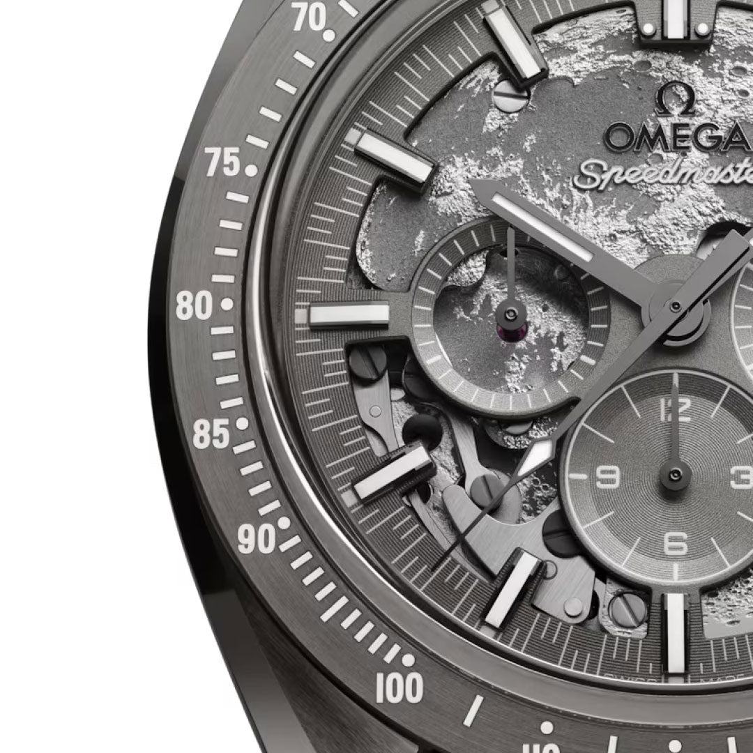 Close-up of the OMEGA Speedmaster Dark Side of the Moon Co-Axial Master Chronometer 44.25mm watch face, showcasing intricate dials, luminous hands, number markers, and a moon-inspired textured background.