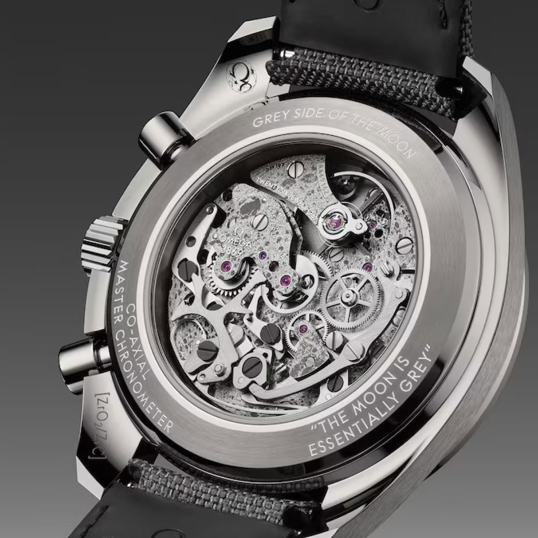 Close-up of the OMEGA Speedmaster Dark Side of the Moon Co-Axial Master Chronometer 44.25mm, highlighting its detailed mechanical movement through a transparent caseback. The Moonwatch features special engravings on its rim.