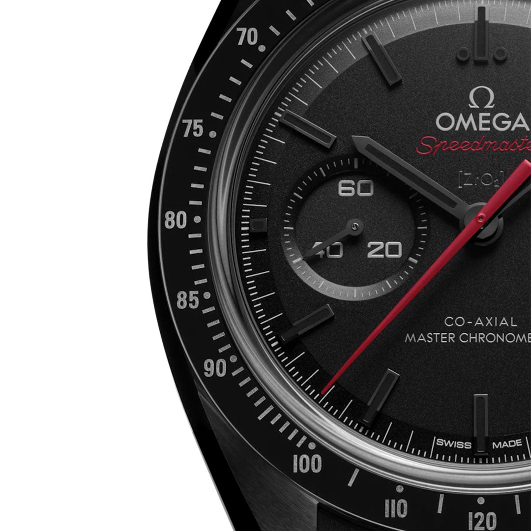Close-up of the right side of the OMEGA Speedmaster Dark Side of the Moon Co-Axial Master Chronometer 44.25mm shows detailed markings, the 9 o’clock subdial, red second hand, and "Co-Axial Master Chronometer" on a black background.