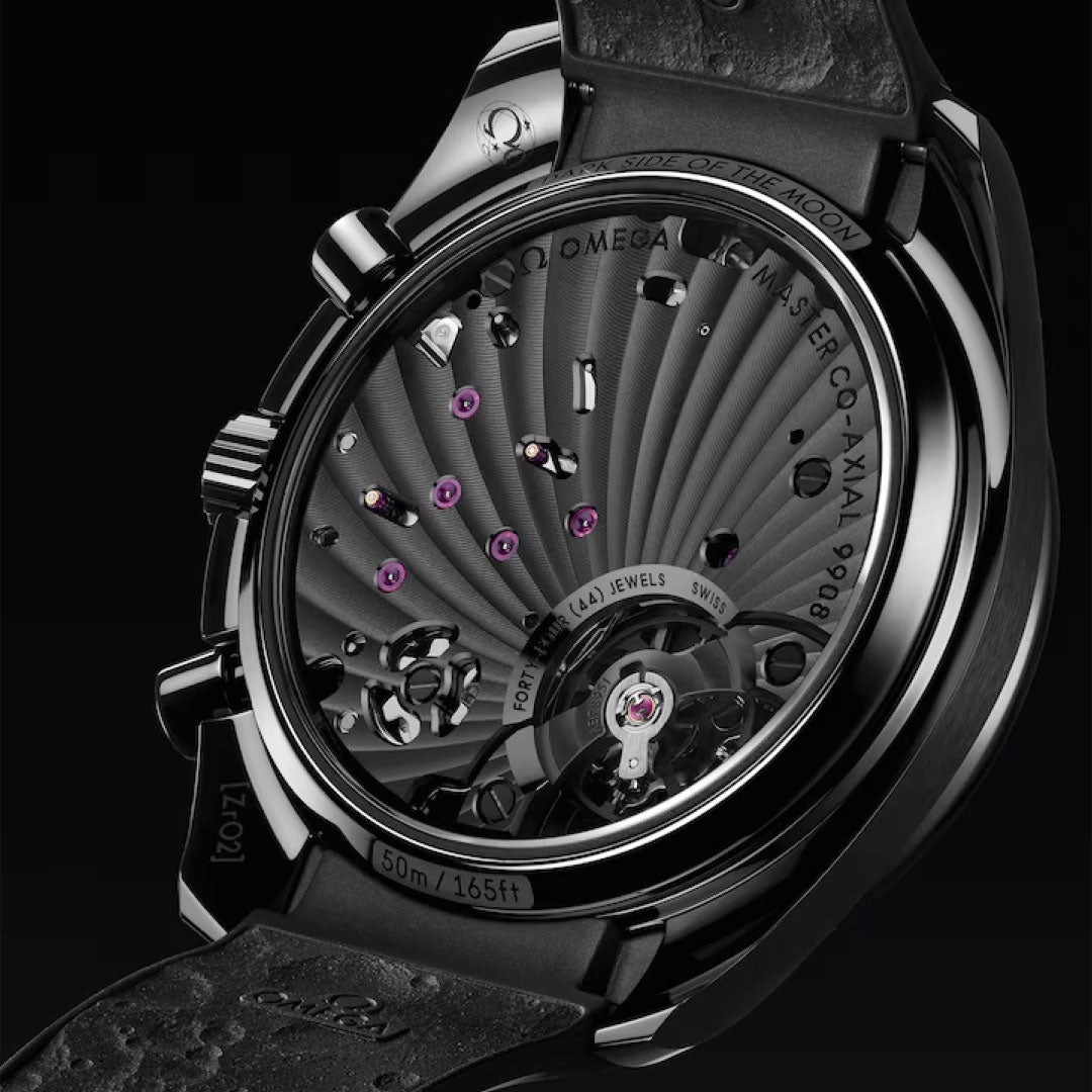 Close-up of the OMEGA Speedmaster Dark Side of the Moon Co-Axial Master Chronometer 44.25mm Watch, showcasing its black ceramic case, detailed movement with jewels, and engraved specs on the back and leather strap.