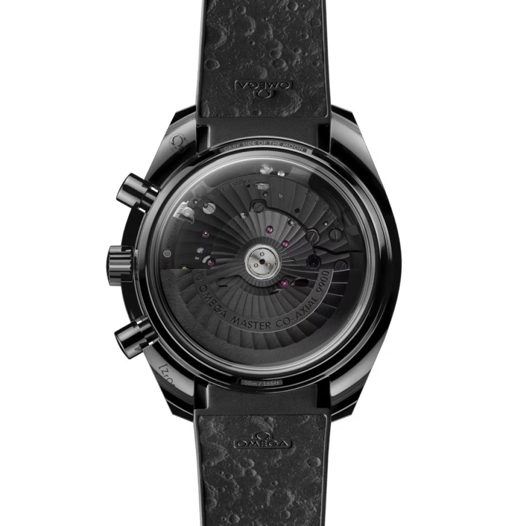 The OMEGA Speedmaster Dark Side of the Moon Co-Axial Master Chronometer 44.25mm Watch is shown from the back, displaying its detailed movement through a transparent case and a textured strap inspired by the Moon’s cratered surface.