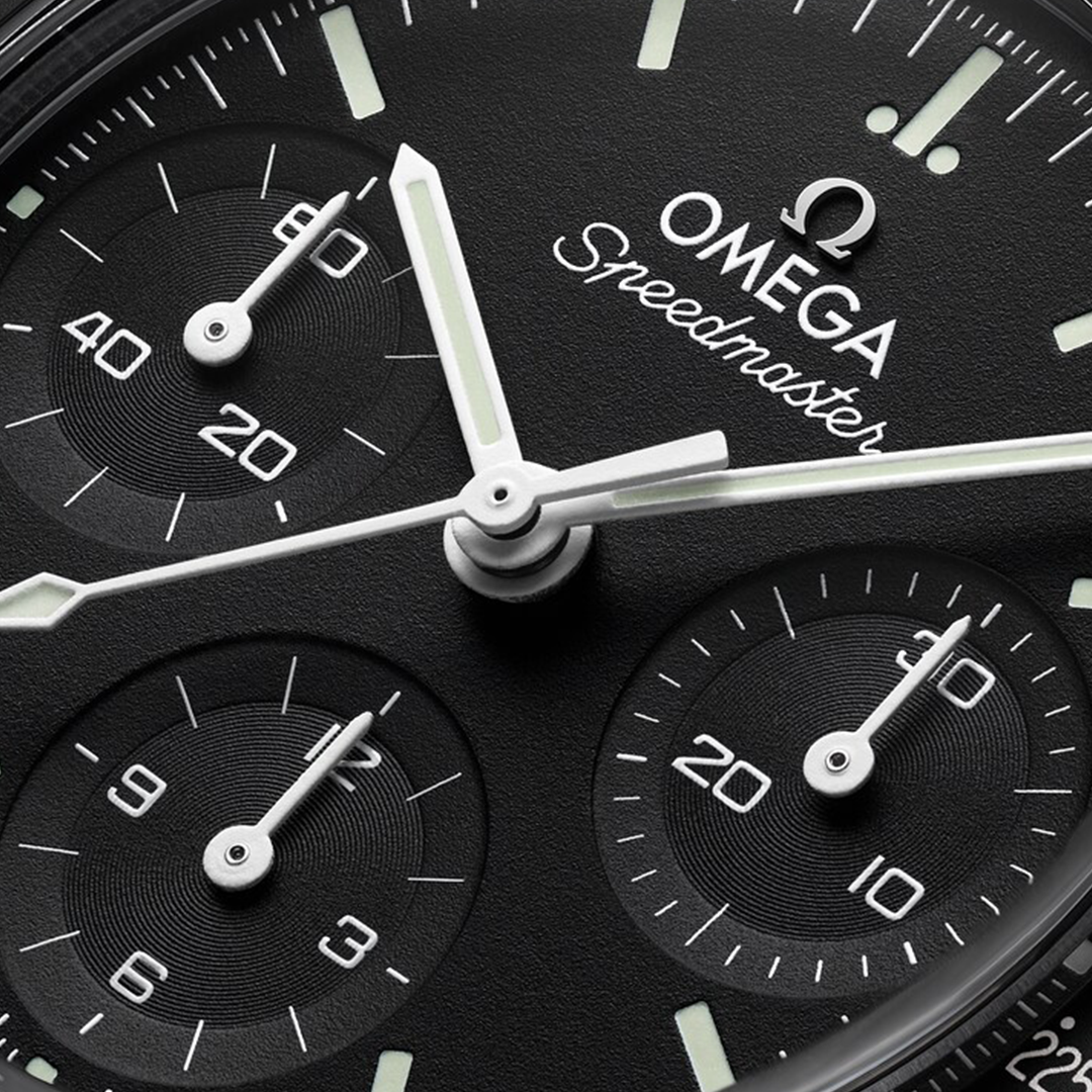 Close-up of an OMEGA Speedmaster 38 Co-Axial Chronometer Chronograph 38mm Watch face featuring a black dial with white hands, luminous hour markers, and three sub-dials.