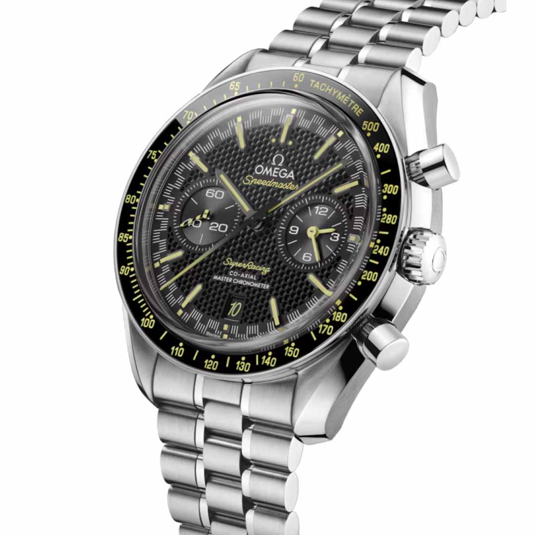 A detailed view of the OMEGA Speedmaster Super Racing Co-Axial Master Chronometer 44.25mm Watch showcases a sophisticated silver design with a black dial and striking yellow accents. The watch face includes three sub-dials and a tachymetric scale adorning the bezel, paired beautifully with a stainless steel bracelet.