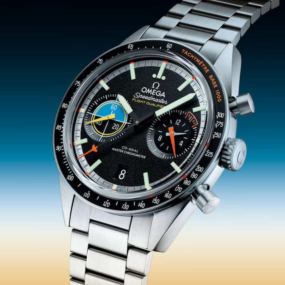 The OMEGA Speedmaster Pilot Co-Axial Master Chronometer 40.85mm, featuring a black dial with multicolored subdials, tachymeter bezel, and stainless steel bracelet, is showcased on a blue-to-beige gradient background.