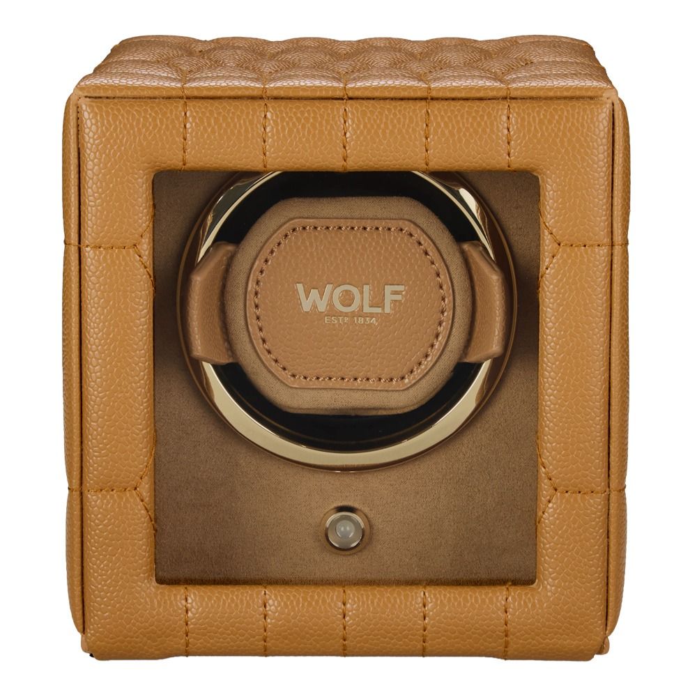 The WOLF 1834 Lauren Single Watch Winder Carmel features a sophisticated tan leather exterior with a quilted square design, a clear front window, and gold “WOLF” branding on the interior pad. Inspired by classic British roadster style, this watch winder seamlessly blends timeless elegance with modern sophistication.